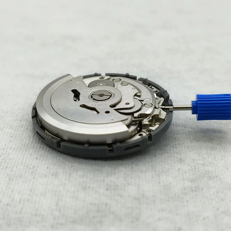 NH35 automatic watch movement with black dial, vibrant orange numerals, date window, and side crown.