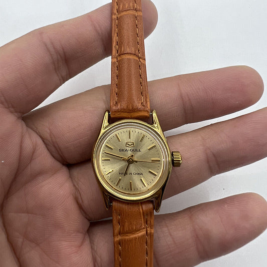 Round golden case ladies watch by China Tianjin Seagull with manual mechanical movement, elegant nail markers.