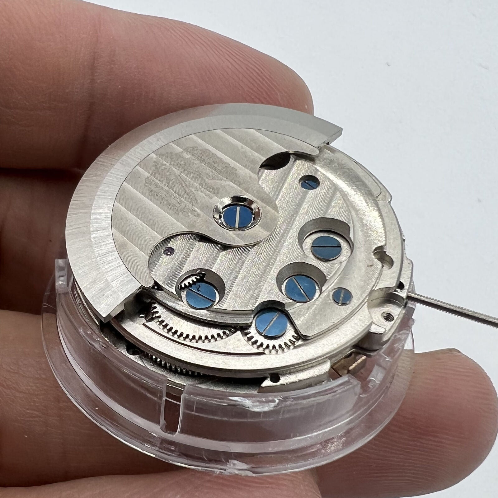 Asian automatic watch with multifunctional date at 12 o?clock and exposed balance wheel detail.