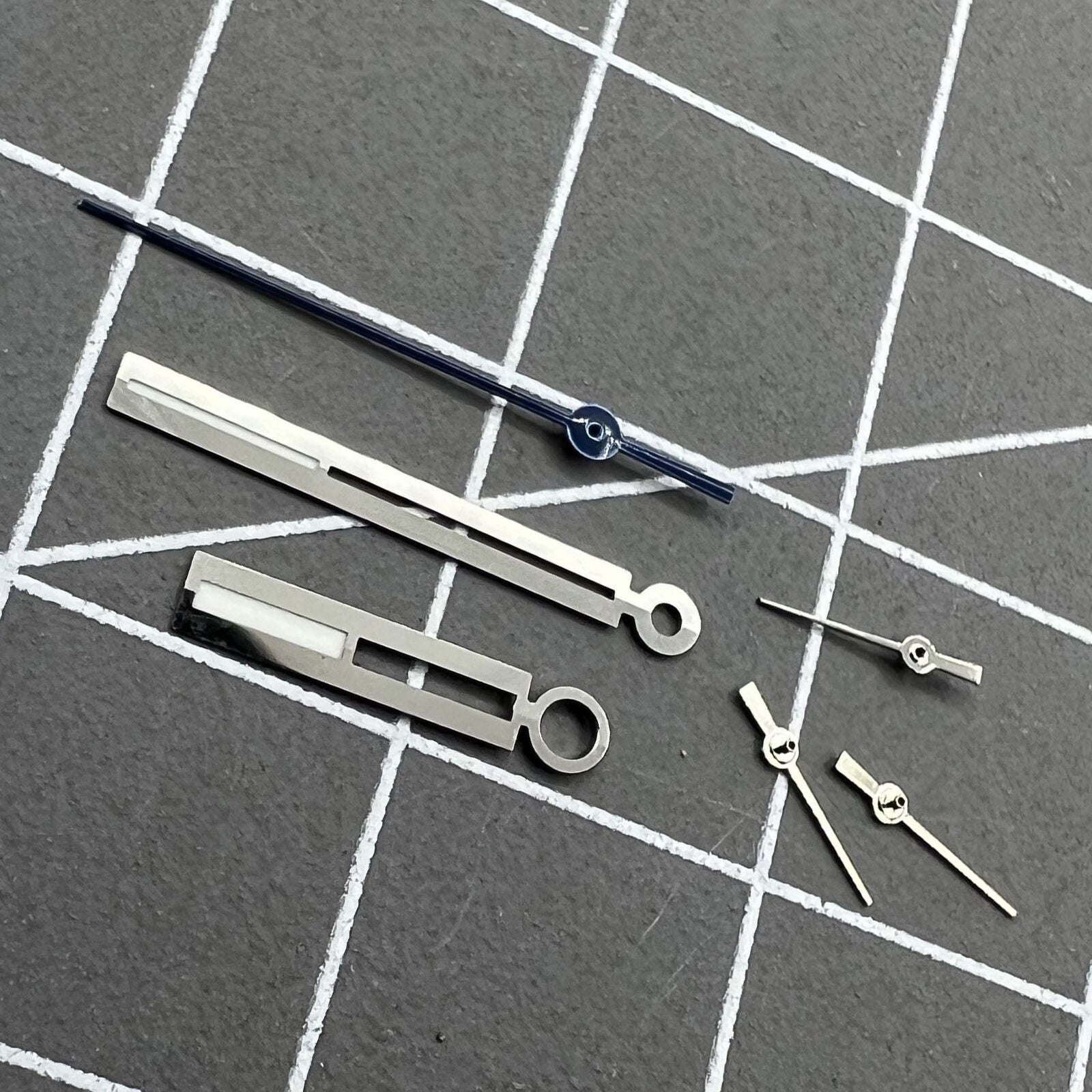 Luminous silver watch hands for Ronda 5021D quartz movement, enhancing readability in low light.