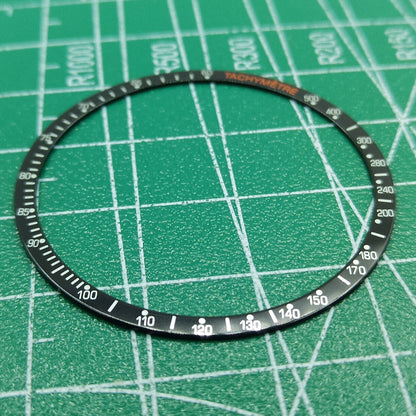 Black aluminum alloy watch bezel with white font, compatible with Omega Speedmaster models, durable replacement ring.