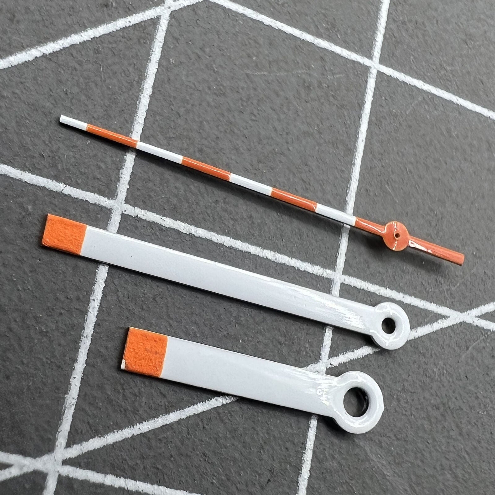 15mm orange and white painted watch hands set for Ronda 515 quartz, ideal for accurate timekeeping.