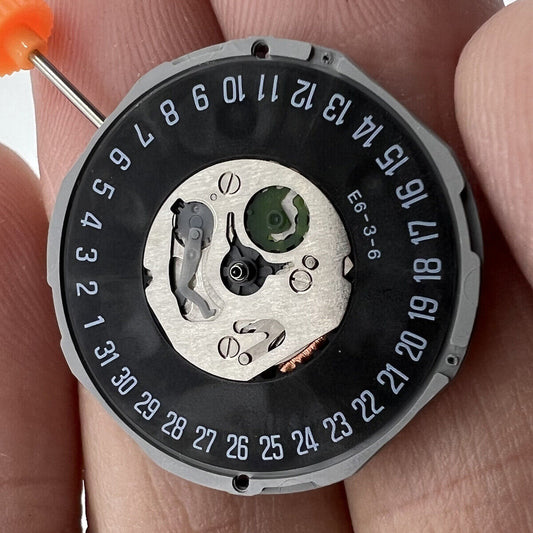 Black dial watch with Miyota 1M12 quartz movement, 3 hands, date at 6, and classic stem design.