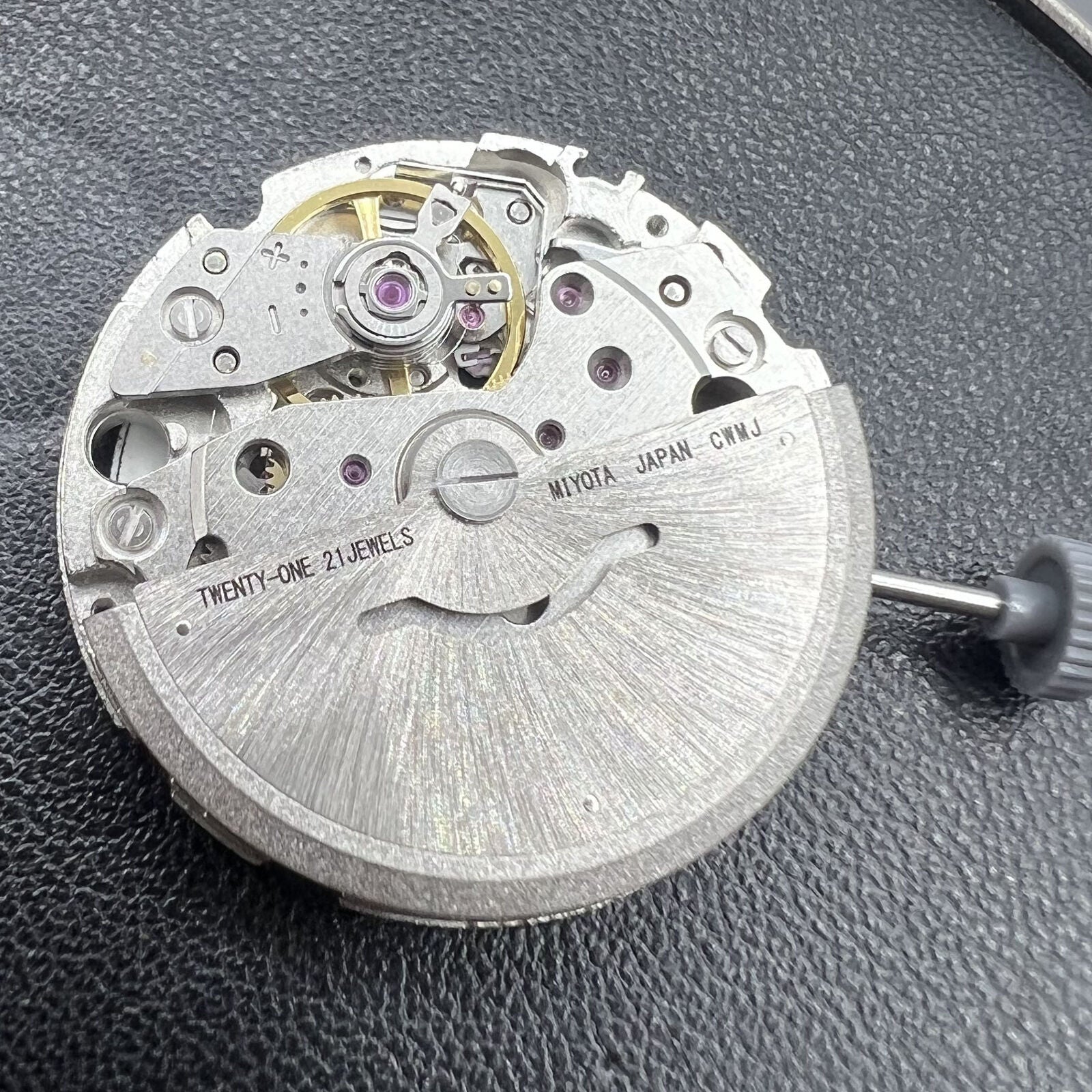 Miyota/Citizen 8215 black dial automatic watch with date at 3, precise mechanical movement.