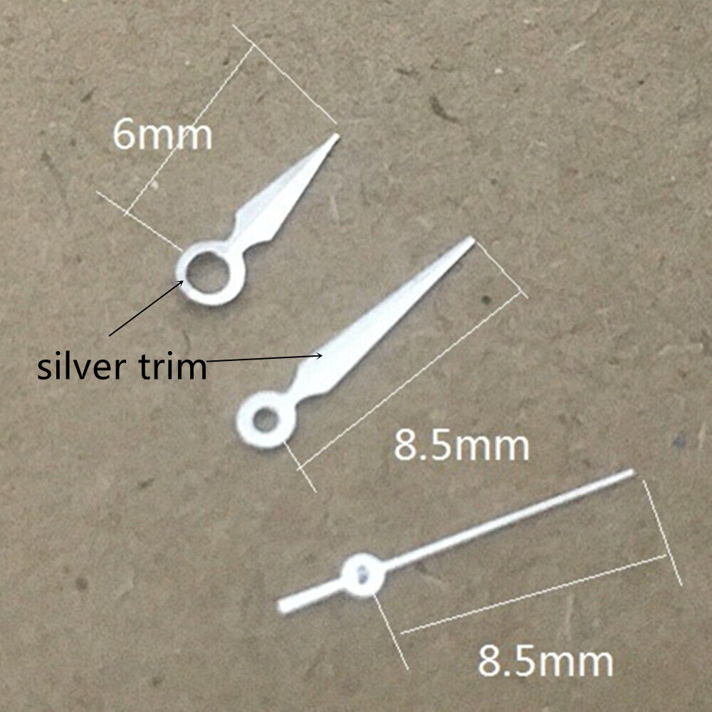 Silver arrow-shaped watch hands with green lume for Miyota 1M12 movement, enhancing visibility and style.