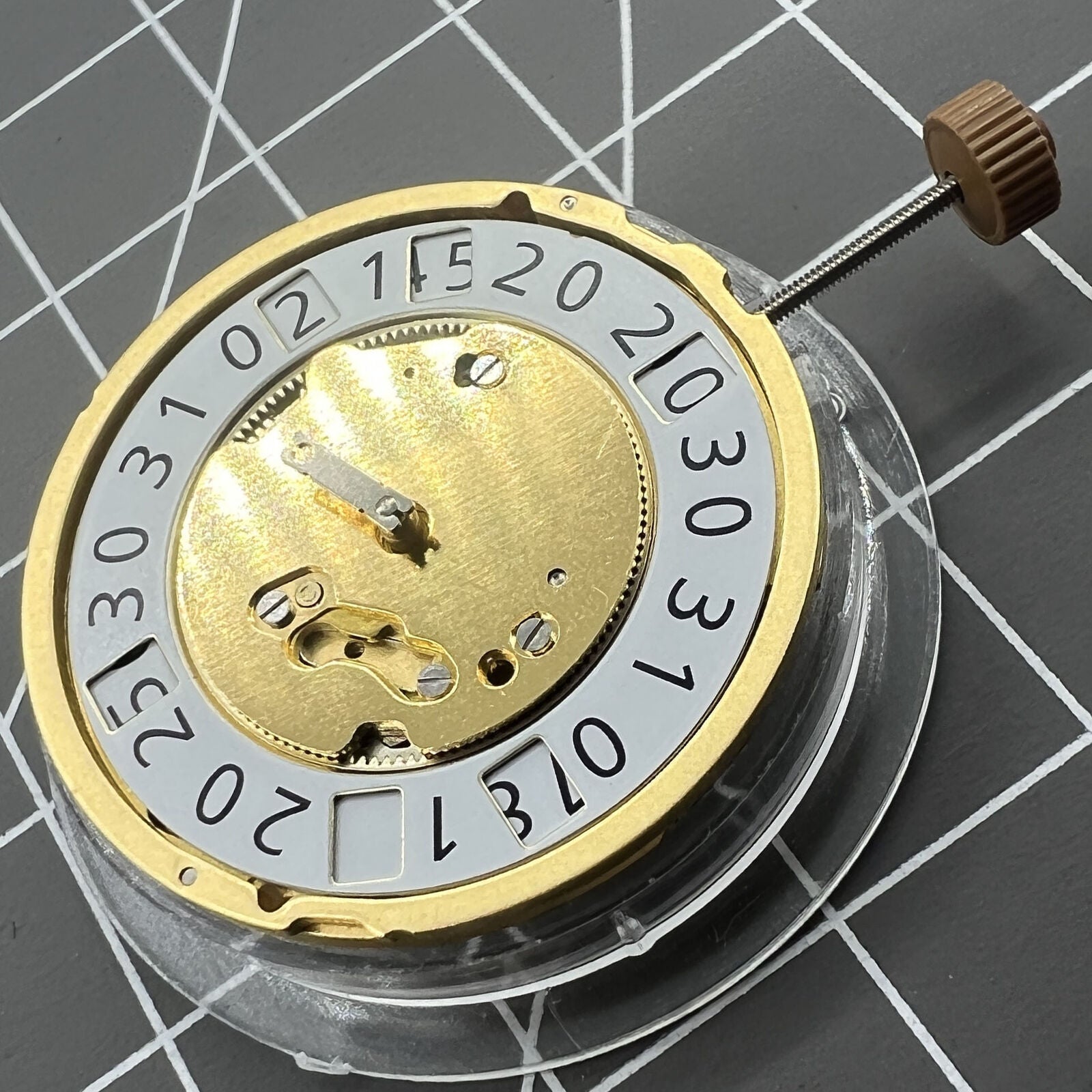 Golden Swiss Made Ronda 6004B quartz watch movement with date display at 12 o'clock, precise timekeeping.