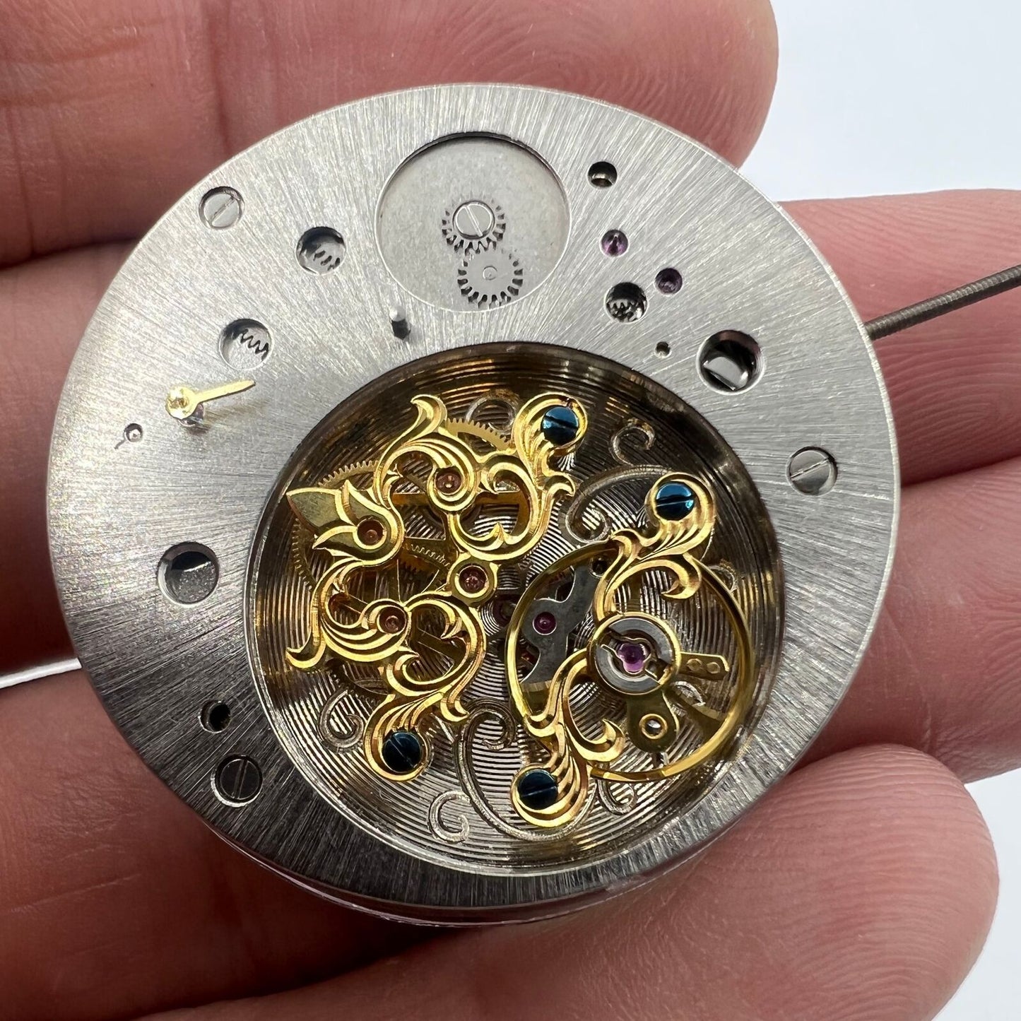 Multifunctional automatic watch featuring kinetic energy tourbillon and sleek mechanical design.