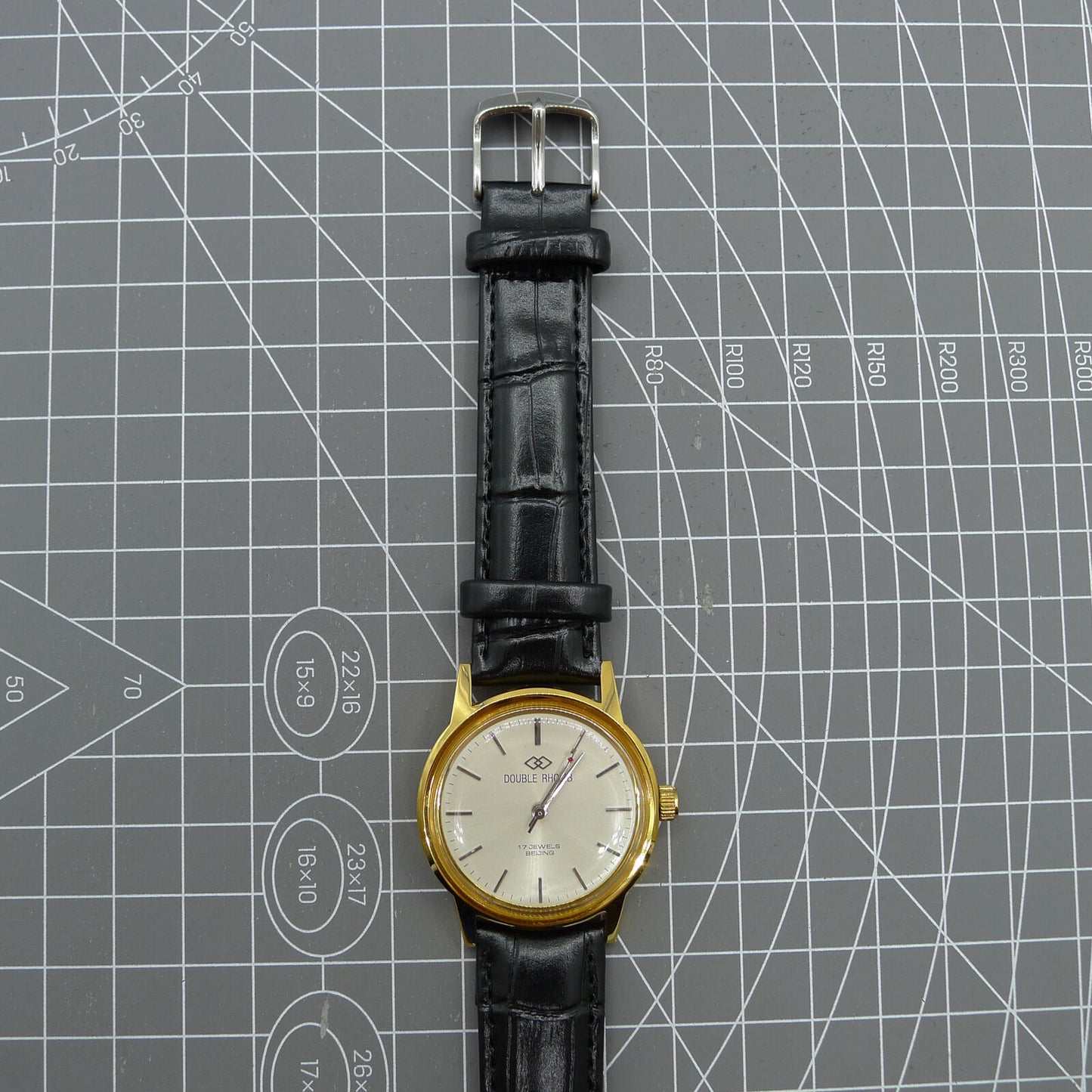 Beijing Double Rhomb watch with golden case, silver nail markers, manual mechanical movement, classic elegance.