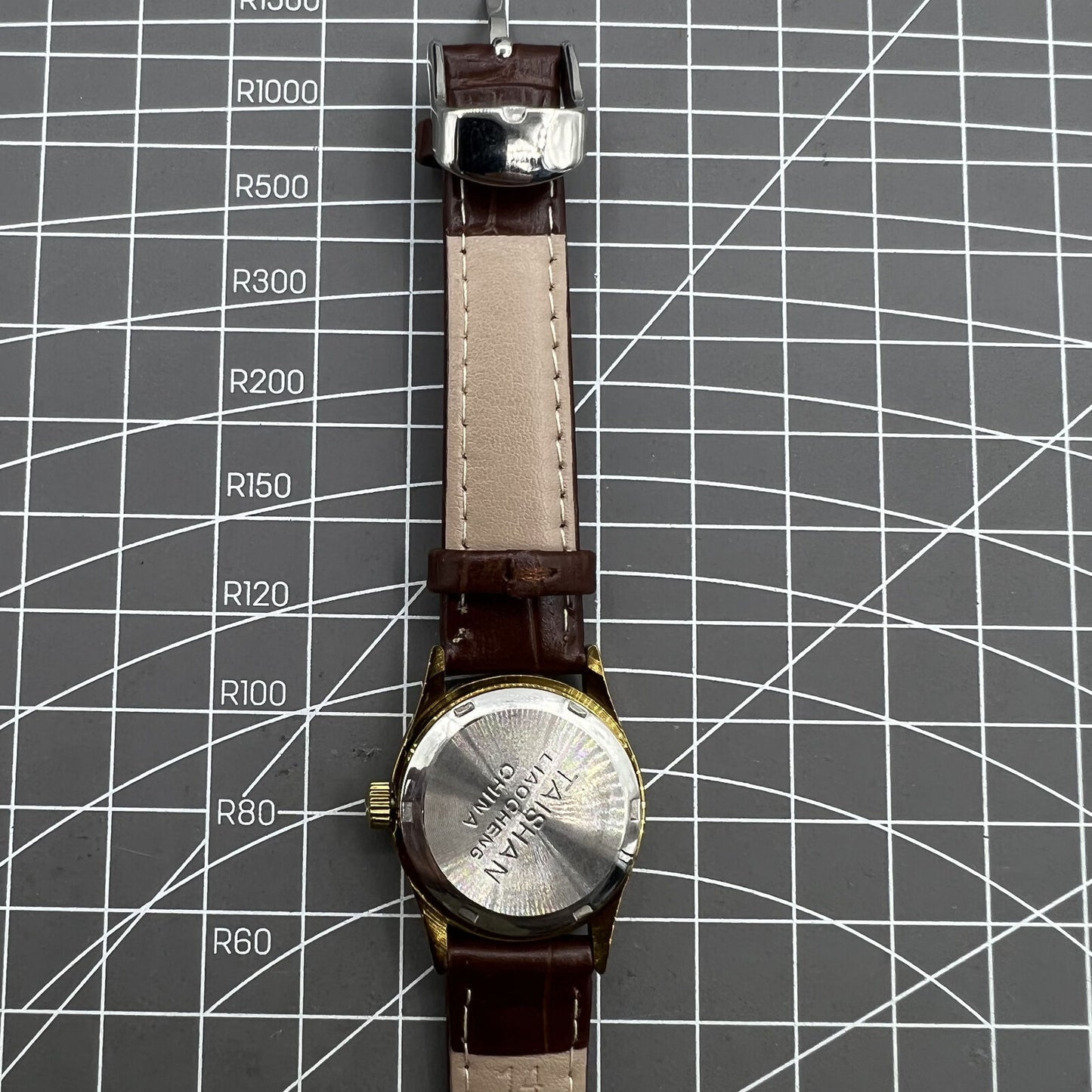 Brown 26mm Liaocheng TAISHAN lady watch with 19-jewel manual mechanical movement and gold nail accents.