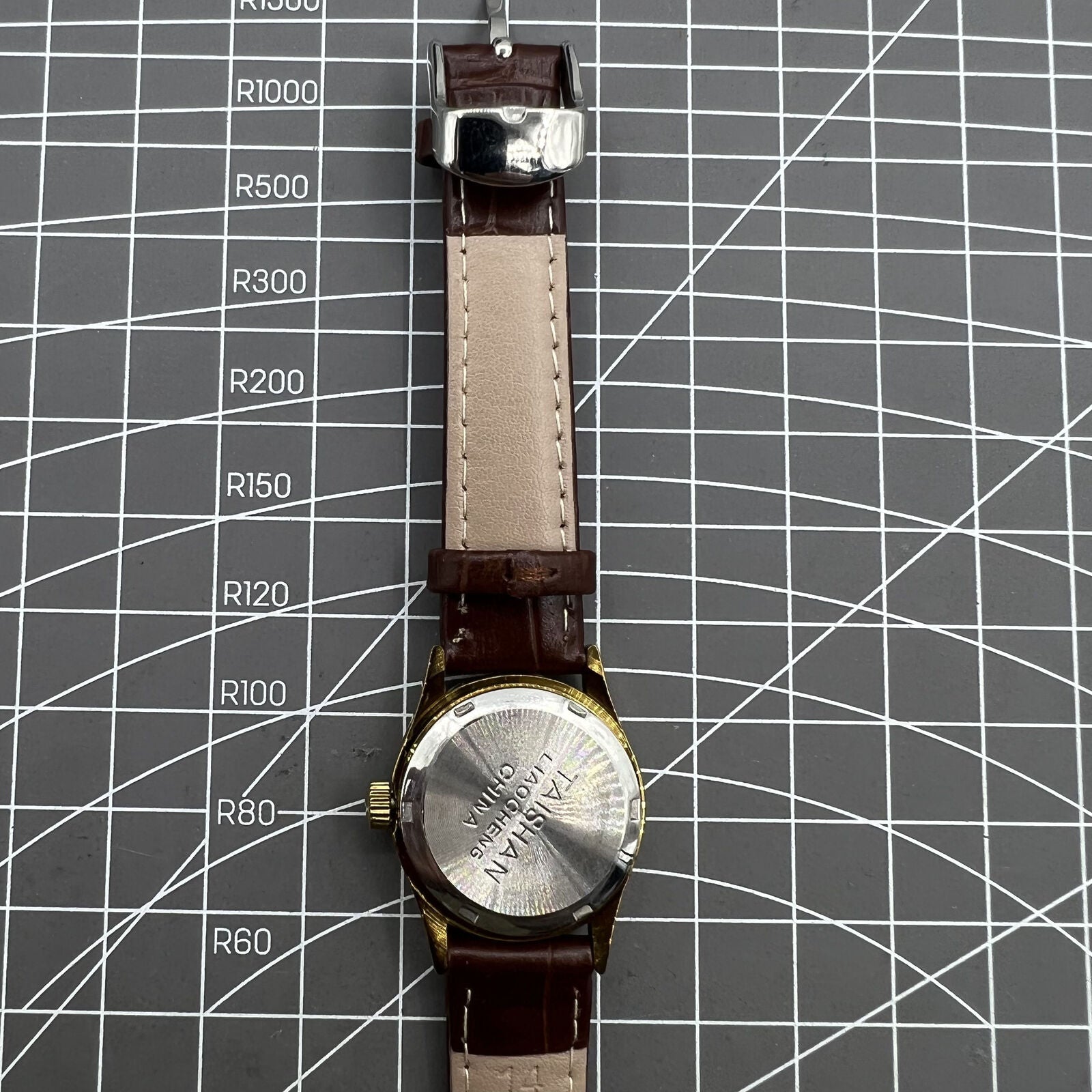 Brown 26mm Liaocheng TAISHAN lady watch with 19-jewel manual mechanical movement and gold nail accents.