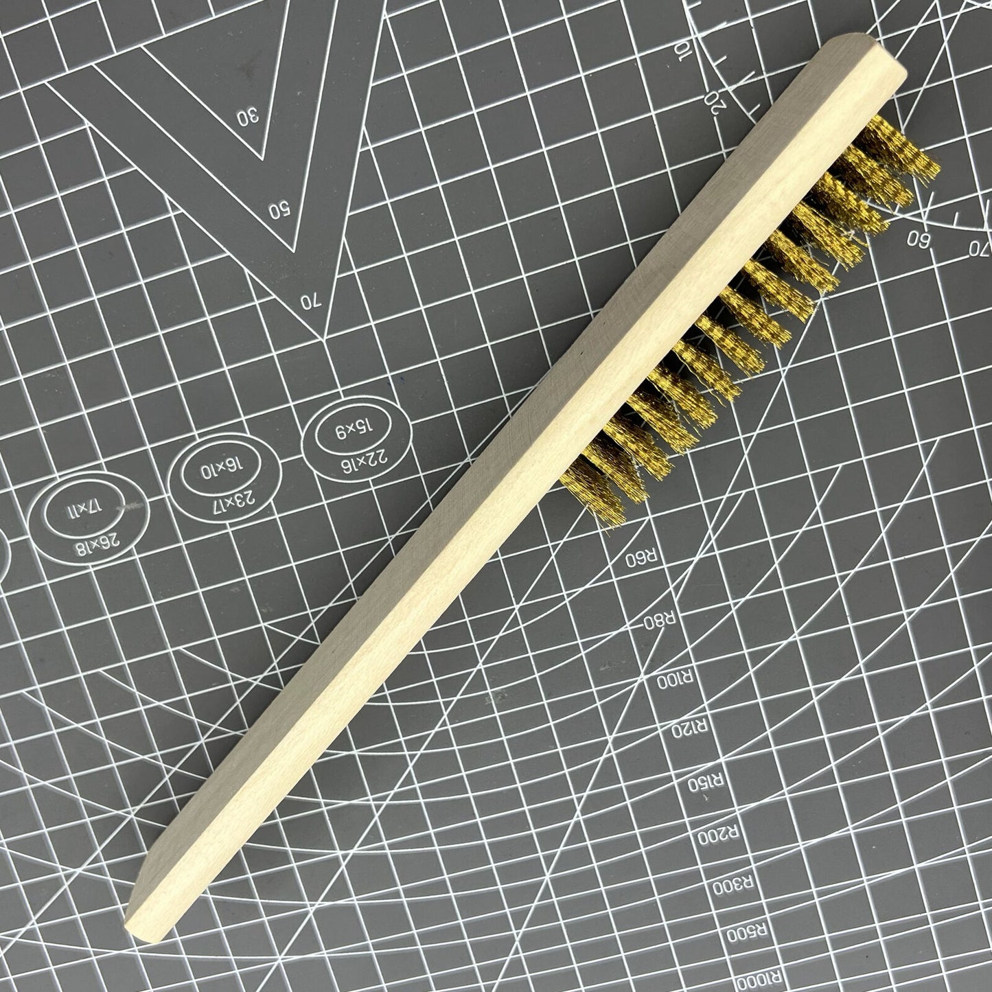 Copper wire brush with wooden handle for rust removal and metal cleaning, perfect for jewelry making tools.