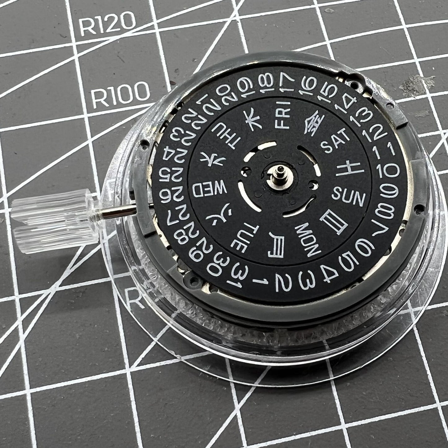 Miyota NH36A automatic movement with black finish and blue lume, showing crown at 3/3.8 position for precise timekeeping.