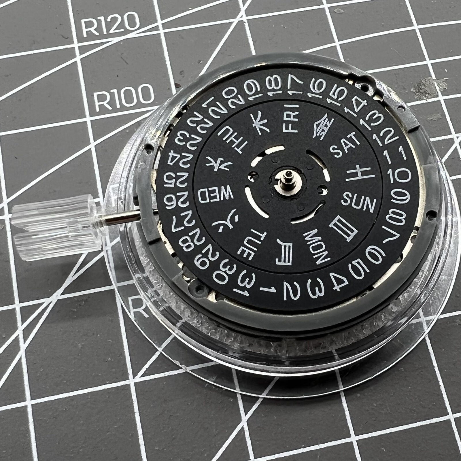 Miyota NH36A automatic movement with black finish and blue lume, showing crown at 3/3.8 position for precise timekeeping.