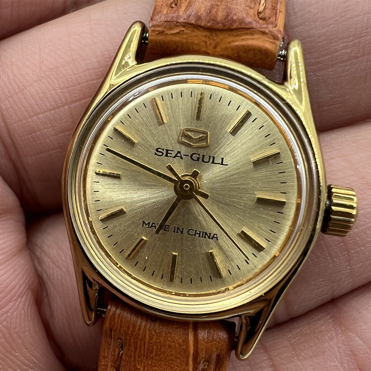 Round golden case ladies watch by China Tianjin Seagull with manual mechanical movement, elegant nail markers.