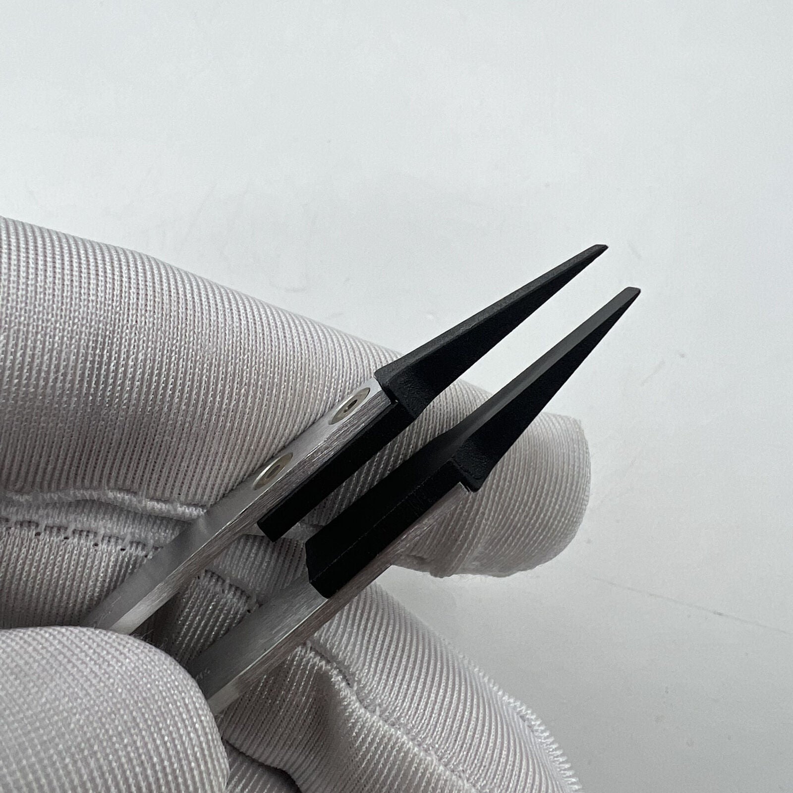 Swiss Made Horotec MSA12.711 carbon fibre tweezers with broad flat tips for precise watch repair handling.