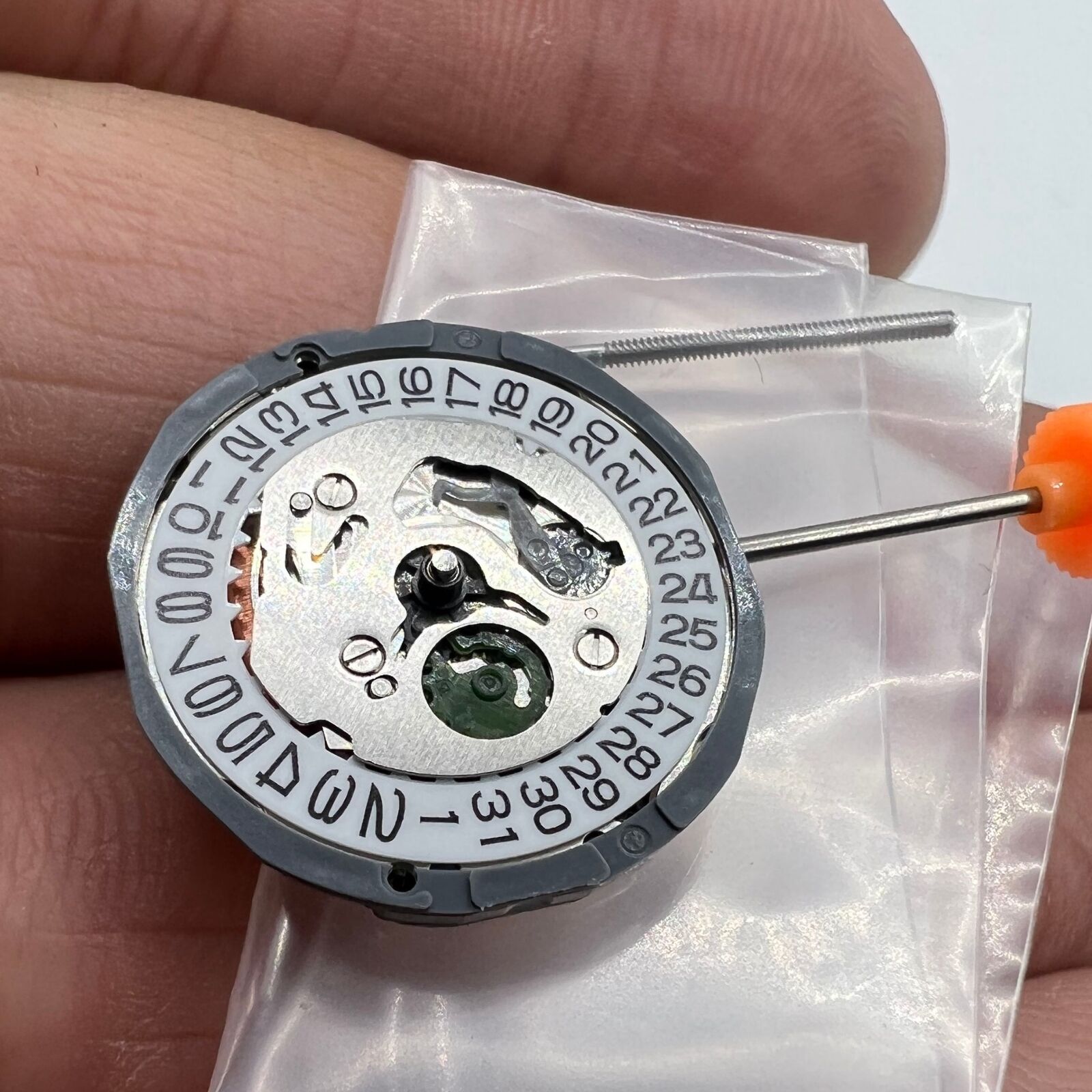 Miyota 1L15 Japan Quartz watch movement with date display at 3 o'clock, precise timekeeping mechanism.