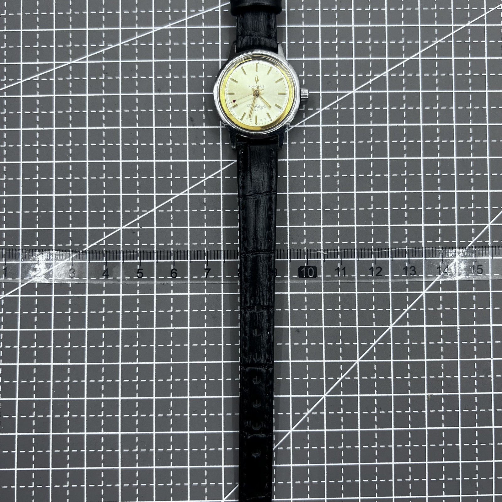 27mm Kongque watch with black leather strap, silver dial, gold hour markers, manual mechanical movement, 19 jewels.