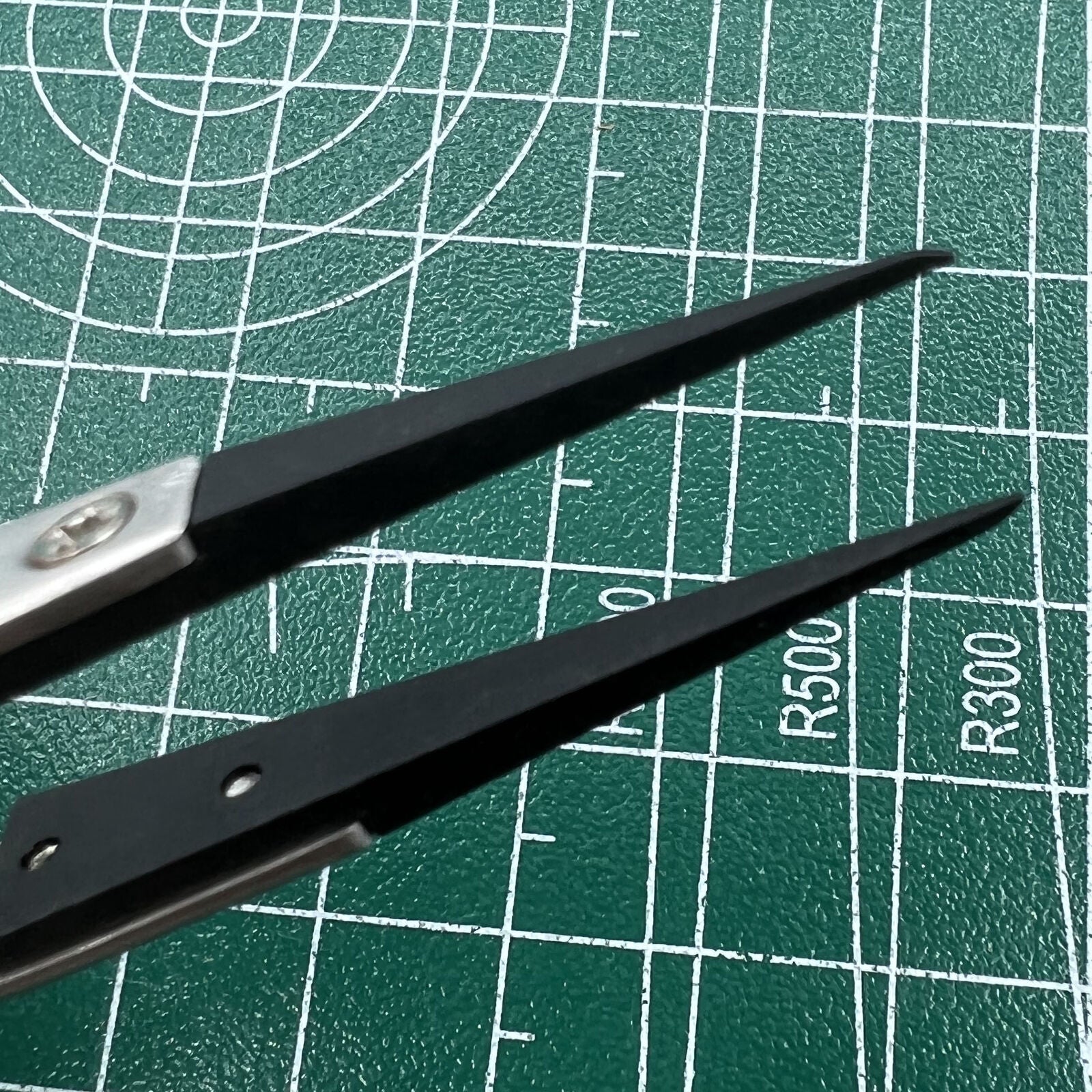 Stainless steel tweezers with carbon fiber tips, perfect for precise watch repair tasks.