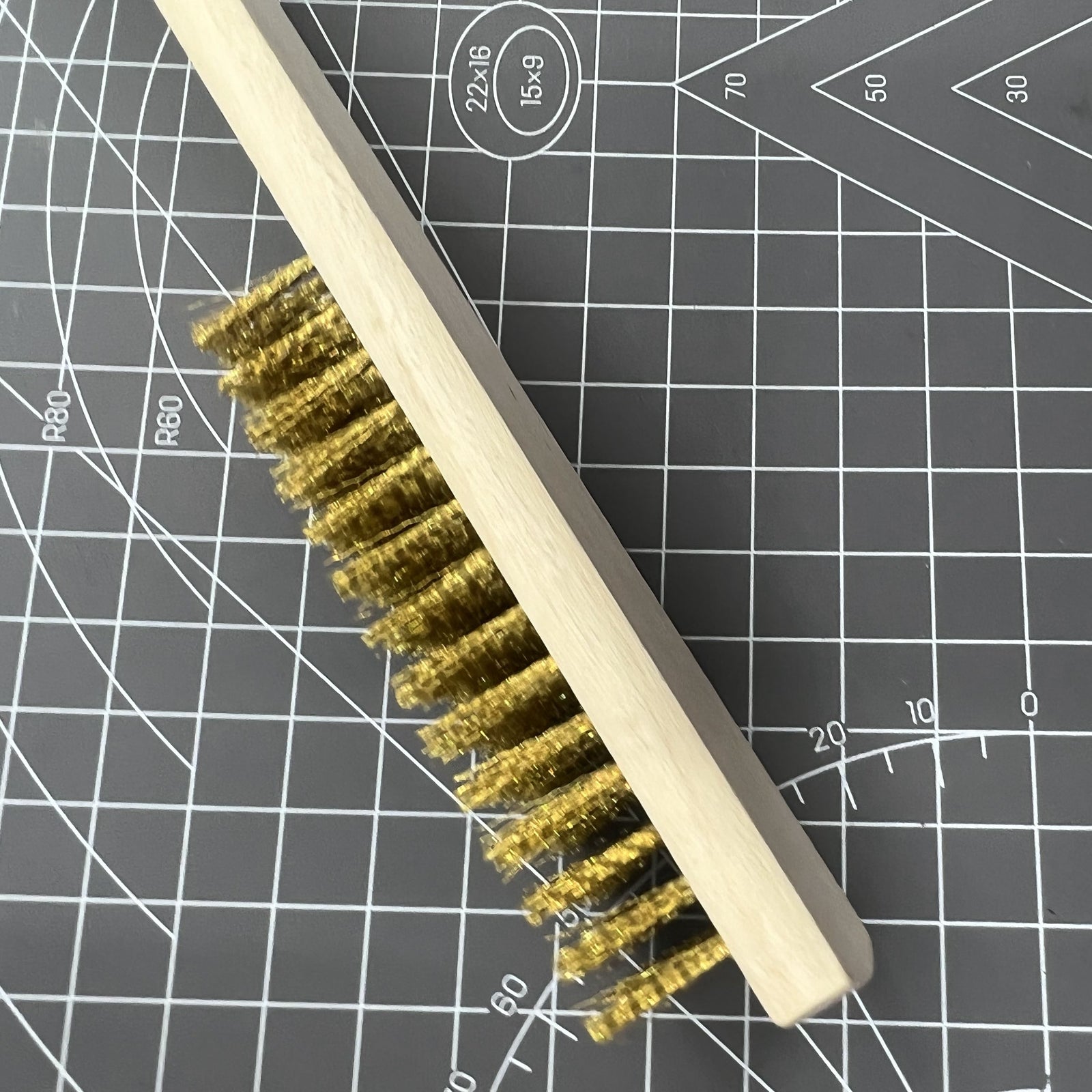 Copper wire brush with wooden handle, perfect for rust removal and jewelry making tool cleaning.