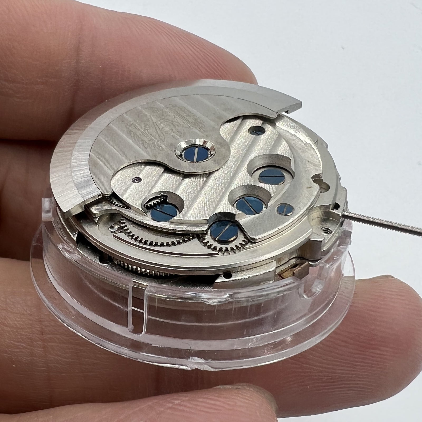 Asian brand multifunctional watch showing date at 12 o'clock and bare balance wheel, automatic mechanical movement.