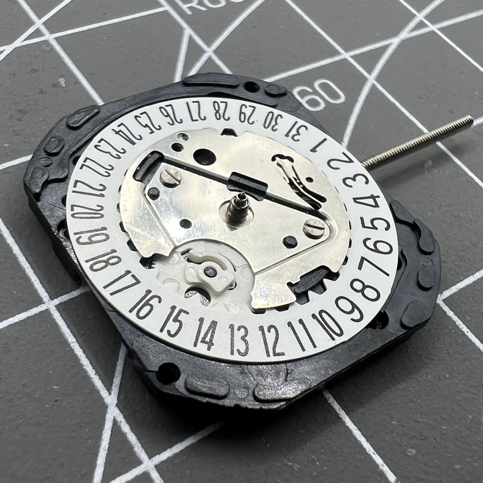 Seiko VX22 quartz watch movement with white date disks at 3 and 6 o'clock, Japan-made precision.