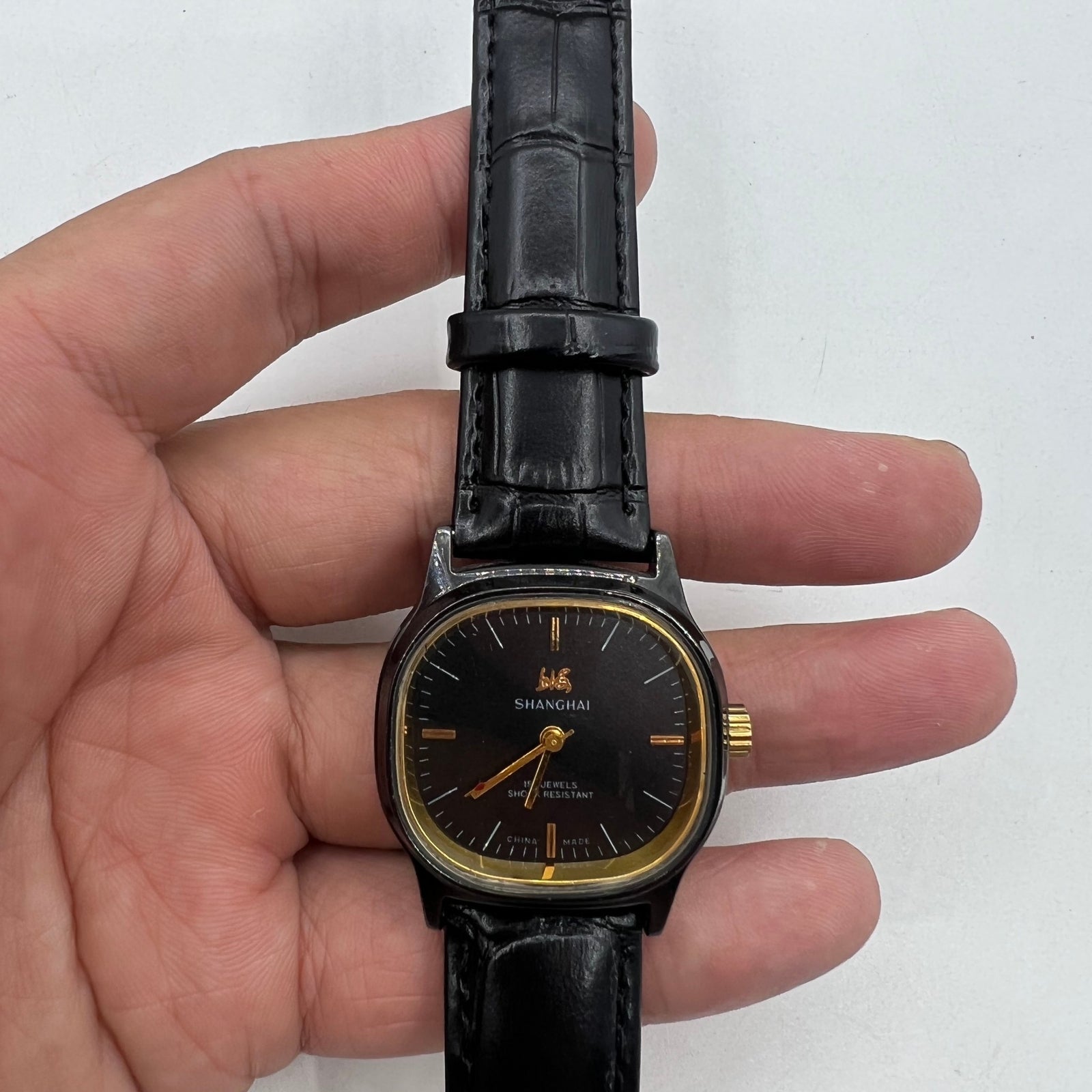 Shanghai Factory 34mm manual mechanical watch with black dial, 19 jewels, shock-resistant design.