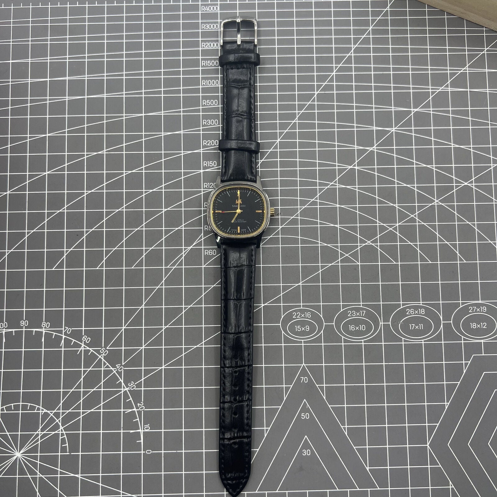 Shanghai Factory 34mm manual mechanical watch with black dial, 19 jewels, and shock-resistant design.