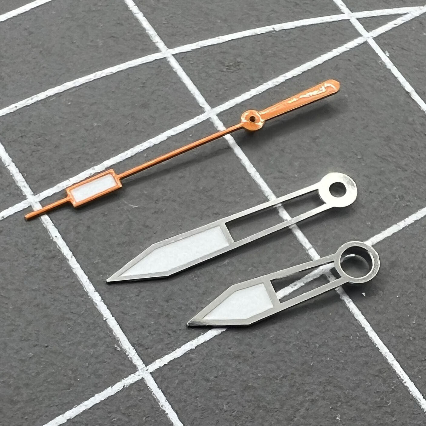 Set aus orangearbenen Ziernbl�ttern mit gr�n leuchtenden Details und silbernen Zeigern, ideal f�r elegante Uhren.