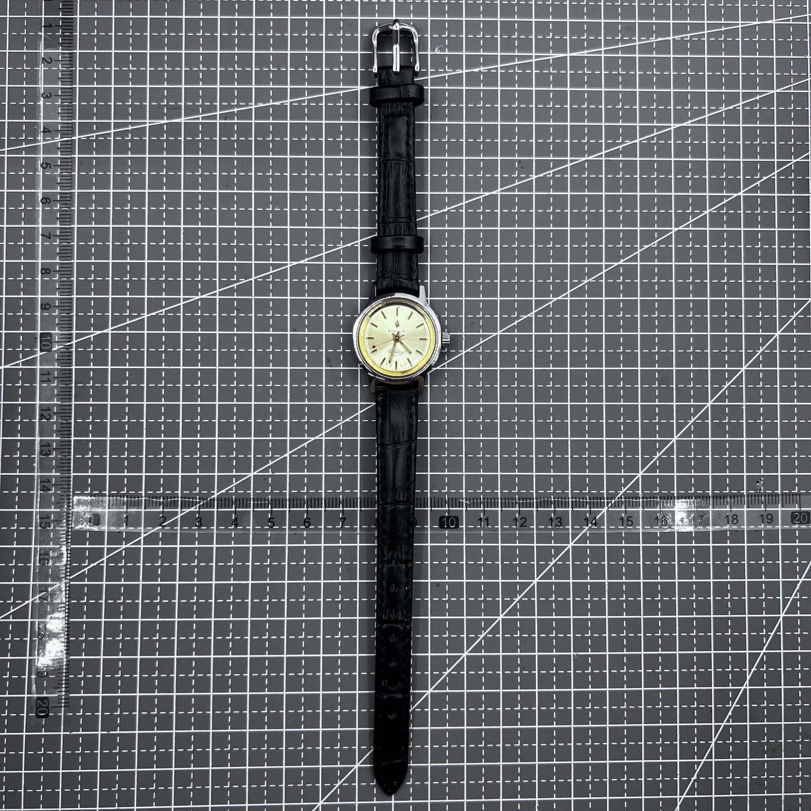 27mm Kongque watch with black strap, silver dial, gold markers, manual mechanical movement, 19 jewels.
