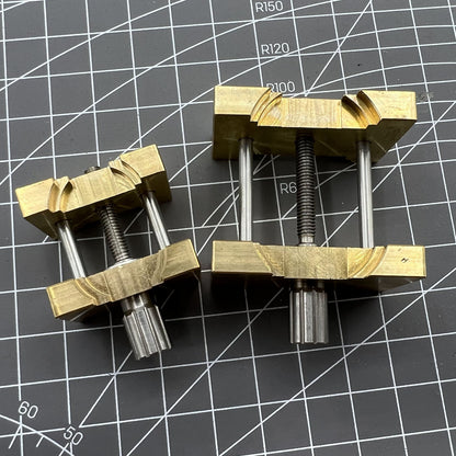 Copper watch movement holder clamp set, ideal for vintage watchmaker repairs and precision adjustments.