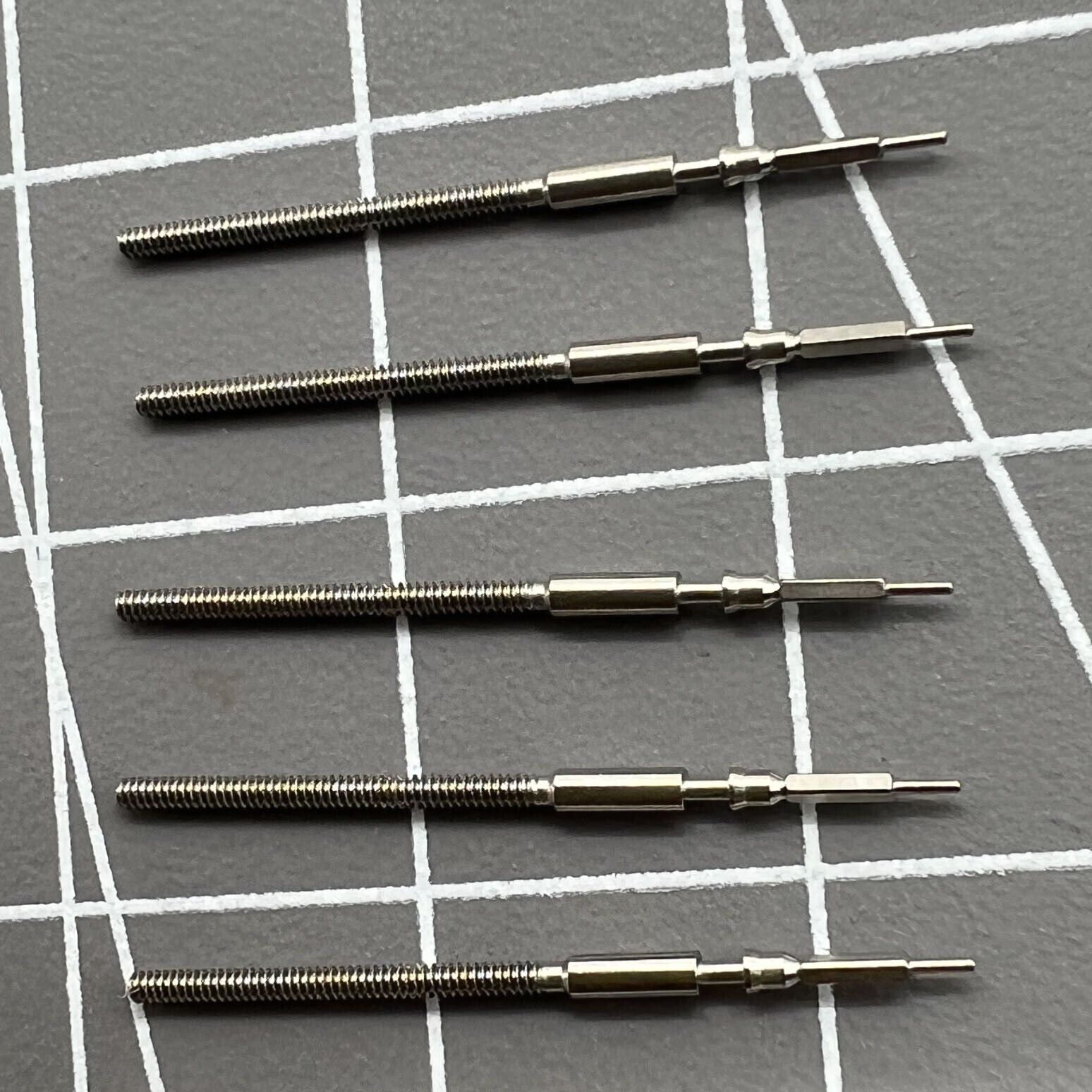Set of five generic watch winding stems for Miyota 9015, compatible with diverse watch models for easy replacement.