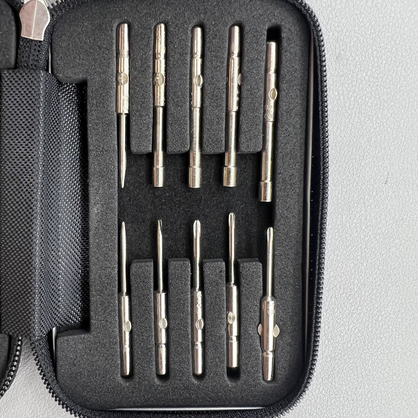 Precision screwdriver set for watch and eyeglass repair, includes hex tools and cutter heads with grip handle.