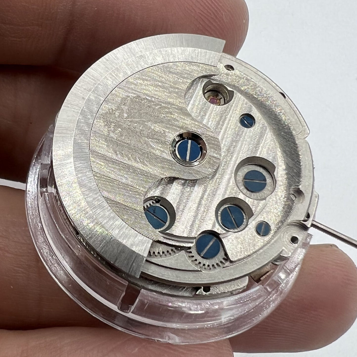 Asian automatic watch showcasing multifunctional date at 12 o?clock and exposed balance wheel, elegant design.