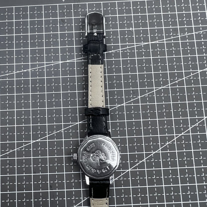 27mm Kongque watch with black leather strap, silver dial, gold markers, manual mechanical movement.