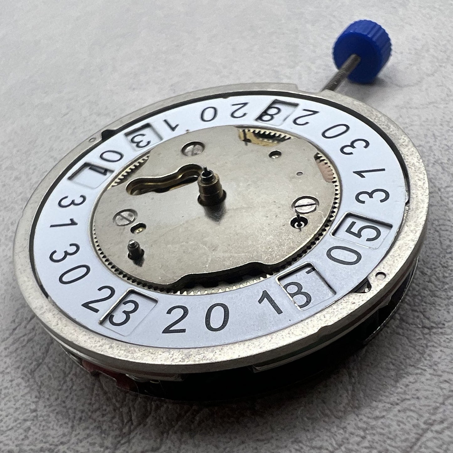 Swiss Ronda 5050B quartz watch movement with date at 6 o'clock and three hands for precise timekeeping.