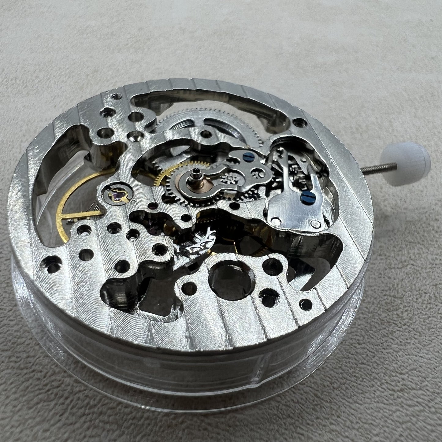 Silver mechanical hand-wound watch case with hollow design for precise timekeeping.