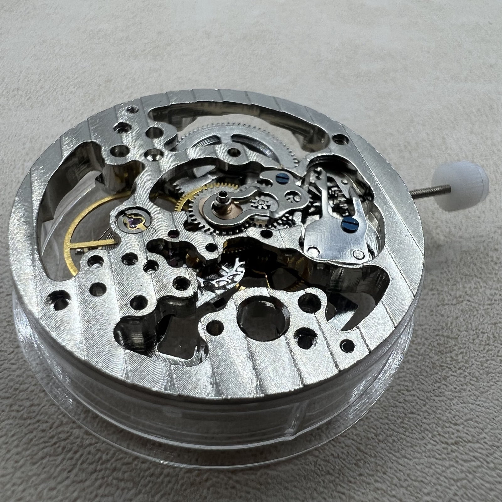 Silver mechanical hand-wound watch case with hollow design for precise timekeeping.