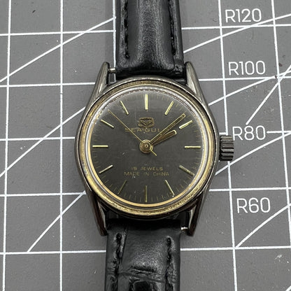 Seagull black case ladies manual mechanical watch with gold nail markers, shock-resistant for lasting durability.