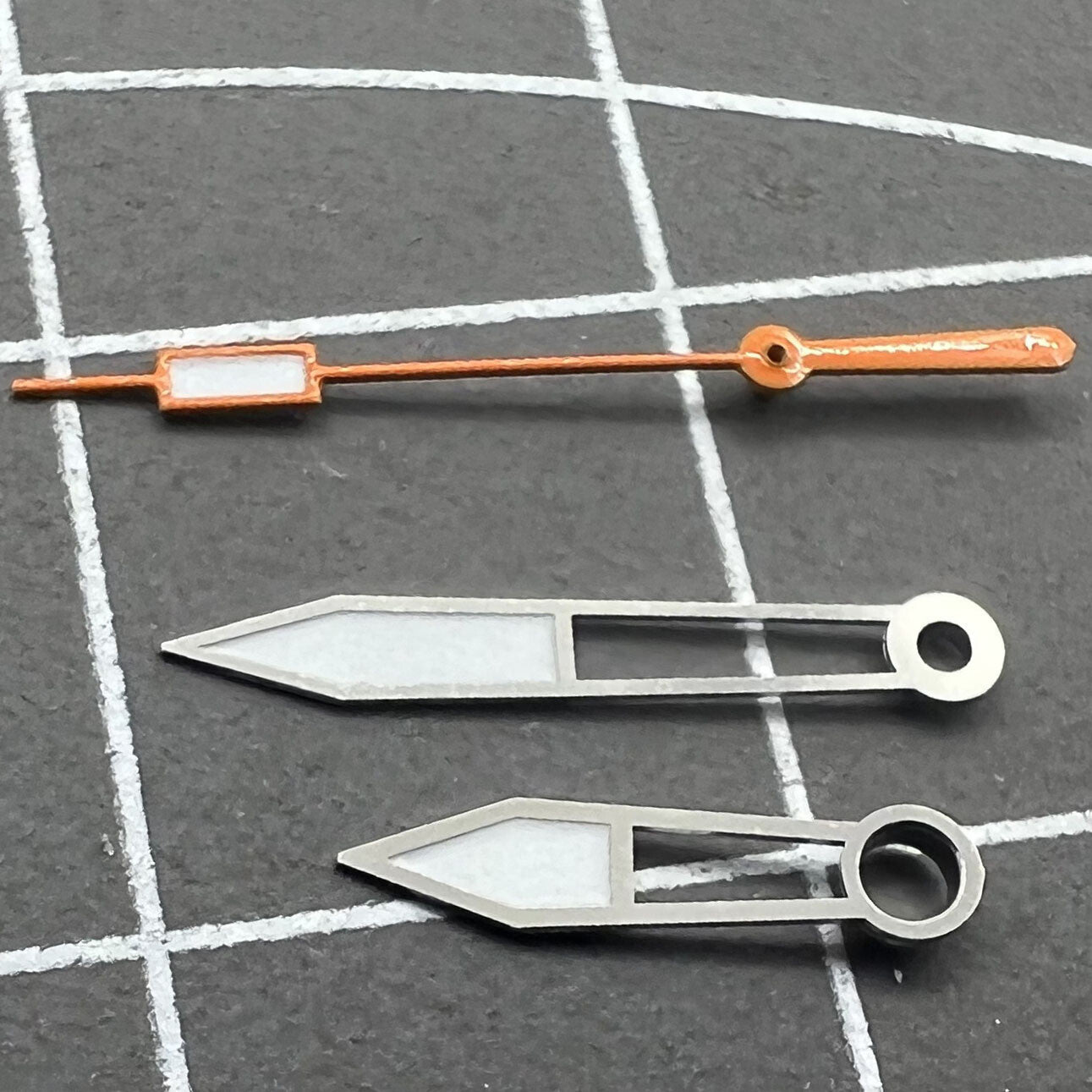 Set aus orangearbenen Ziernbl�ttern mit gr�n leuchtenden Details und silbernen Zeigern, ideal f�r elegante Uhren.