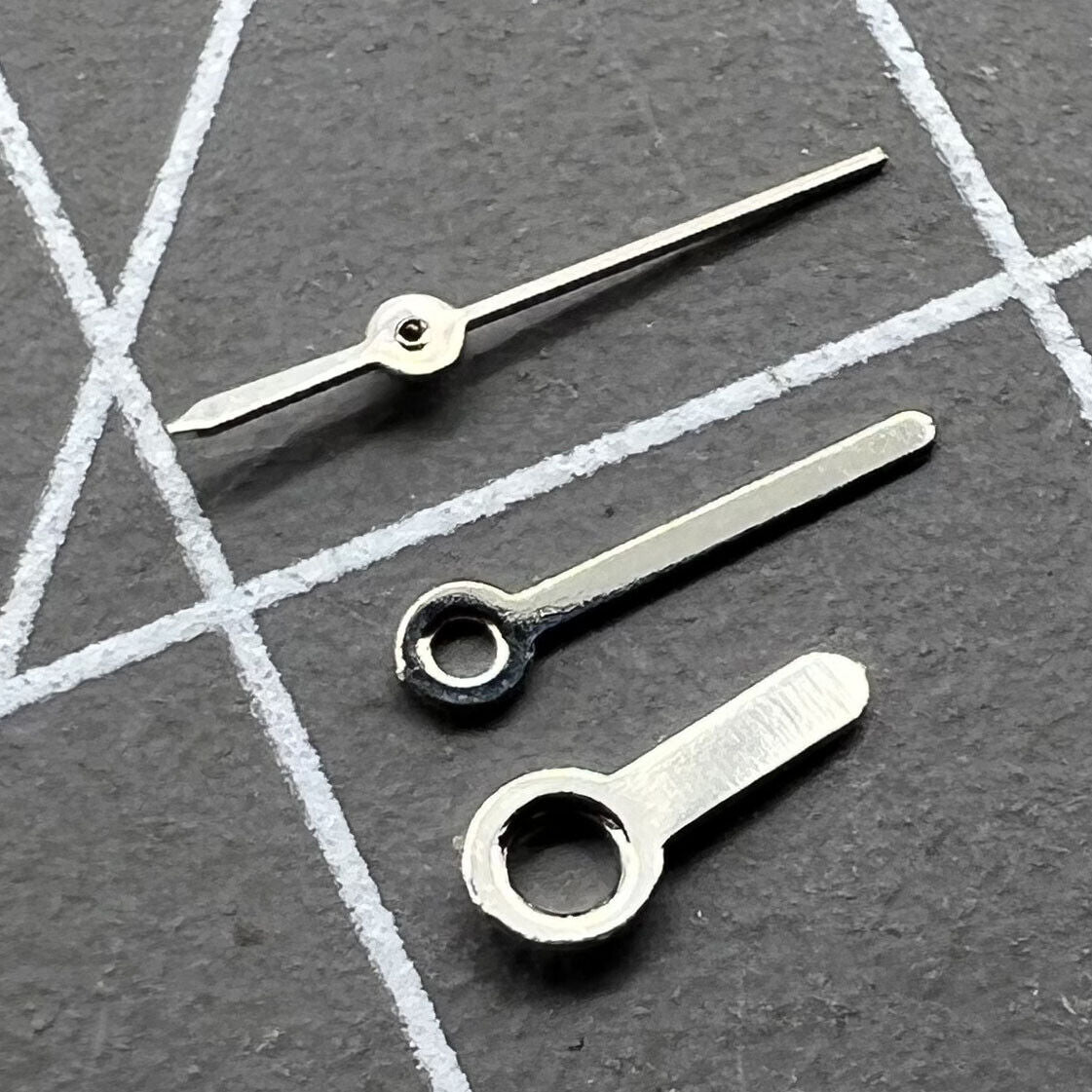 Silver watch hands set by Miyota for 2035, 2115, 2105, 2305 movements, precise and stylish replacement.