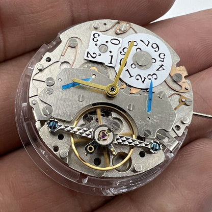 Asian brand multifunctional watch showcasing automatic mechanical movement with date at 12 and visible bare balance wheel.