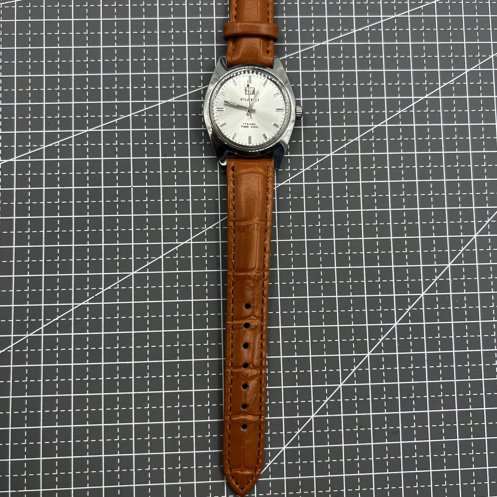 PUBU 32mm manual mechanical watch with grey dial, 17 jewels, and elegant nail indices showcasing Chinese craftsmanship.