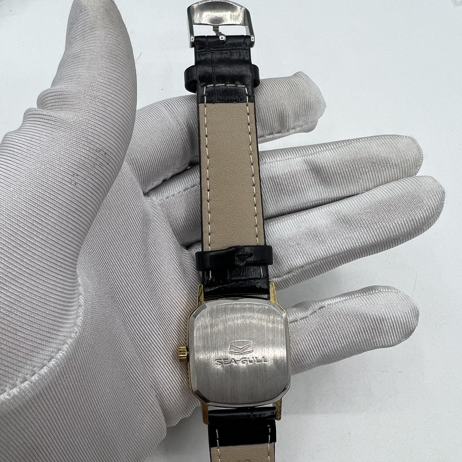 Seagull 28mm ladies watch featuring a golden square case and manual mechanical movement, elegant style.