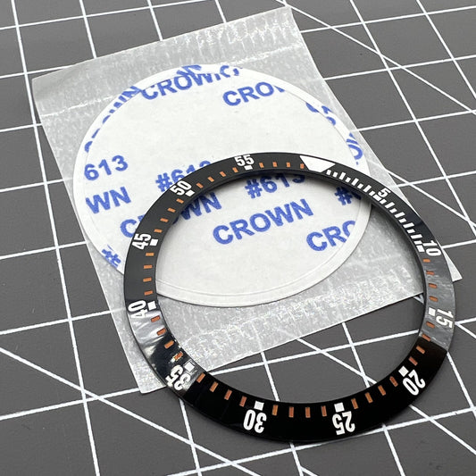 38mm black ceramic watch bezel insert with orange graduation for precise time tracking.