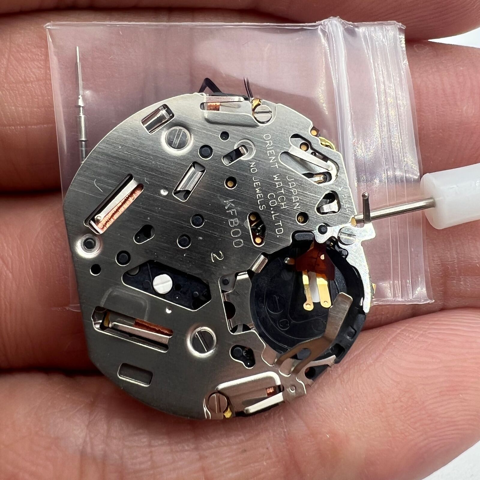 Orient KFB00 quartz watch movement with date window at 3 o'clock, Japan-made for precise replacements.