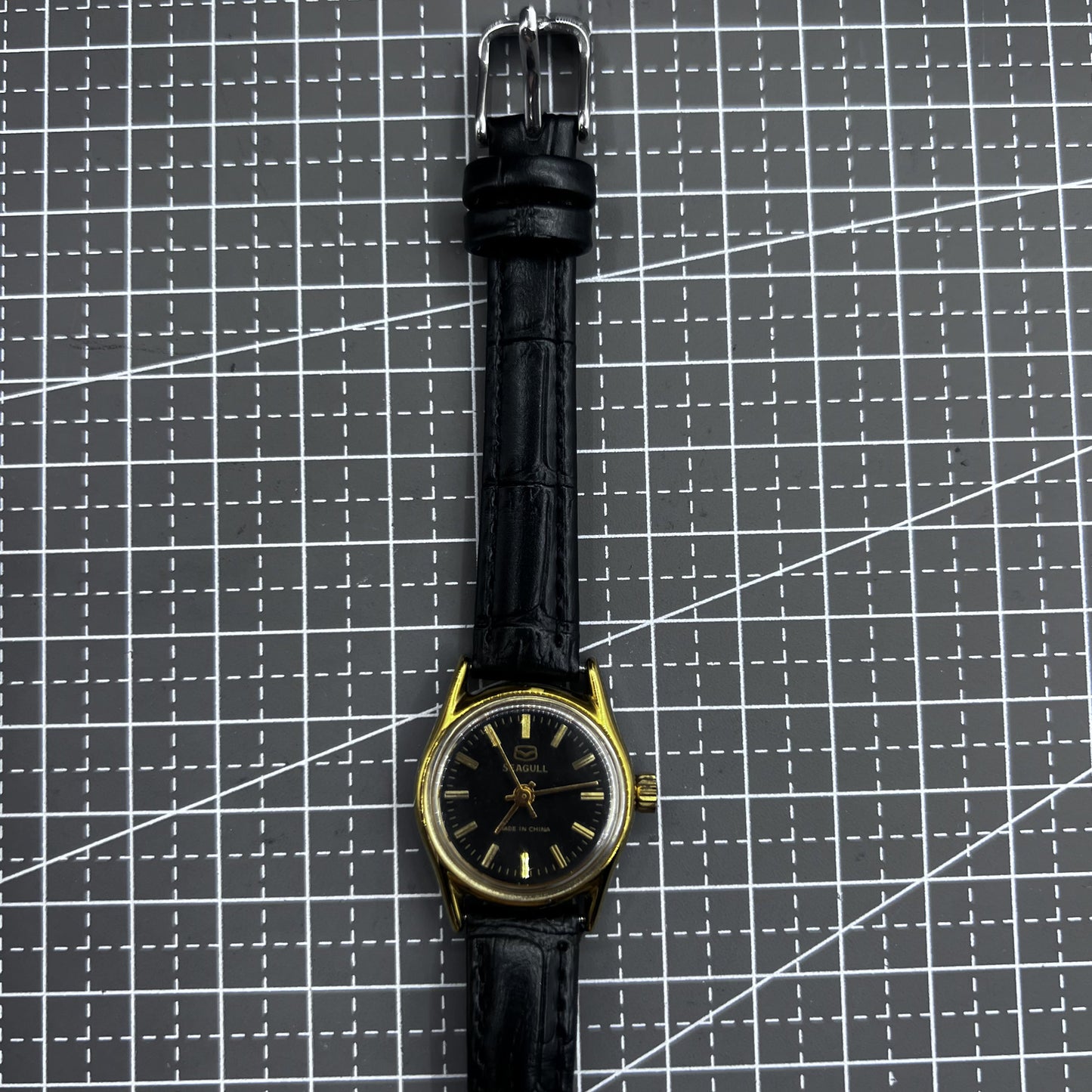 Black round ladies watch with golden accents, Tianjin Seagull manual mechanical movement, elegant style.