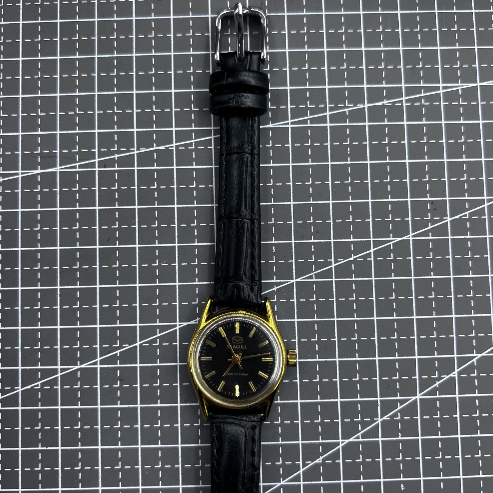 Black round ladies watch with golden accents, Tianjin Seagull manual mechanical movement, elegant style.