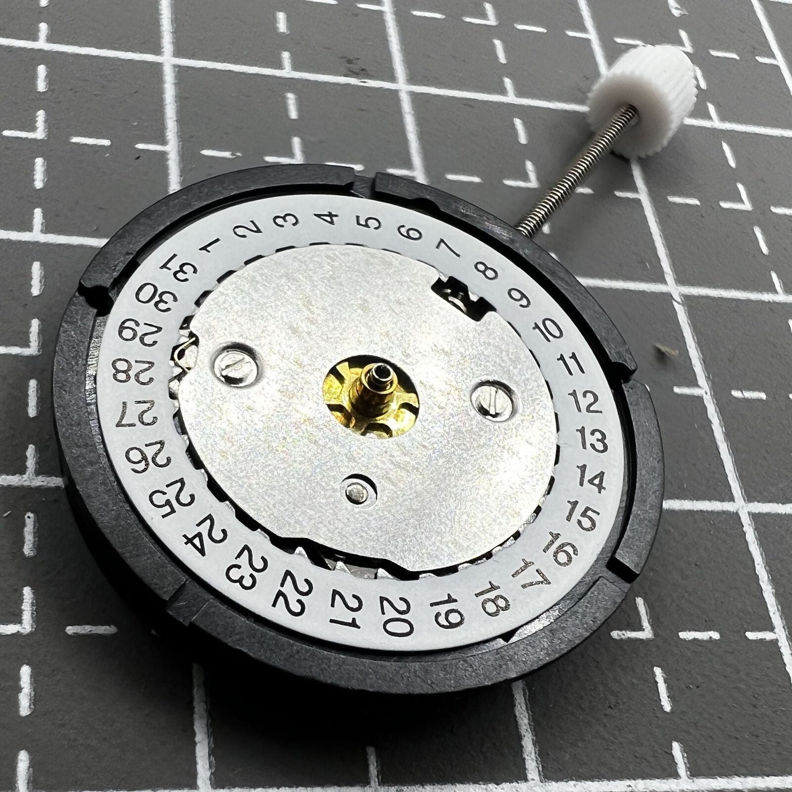Swiss ISA Quarzuhrwerk K83 103 watch movement with date at 3 o'clock and three hands for precision timekeeping.