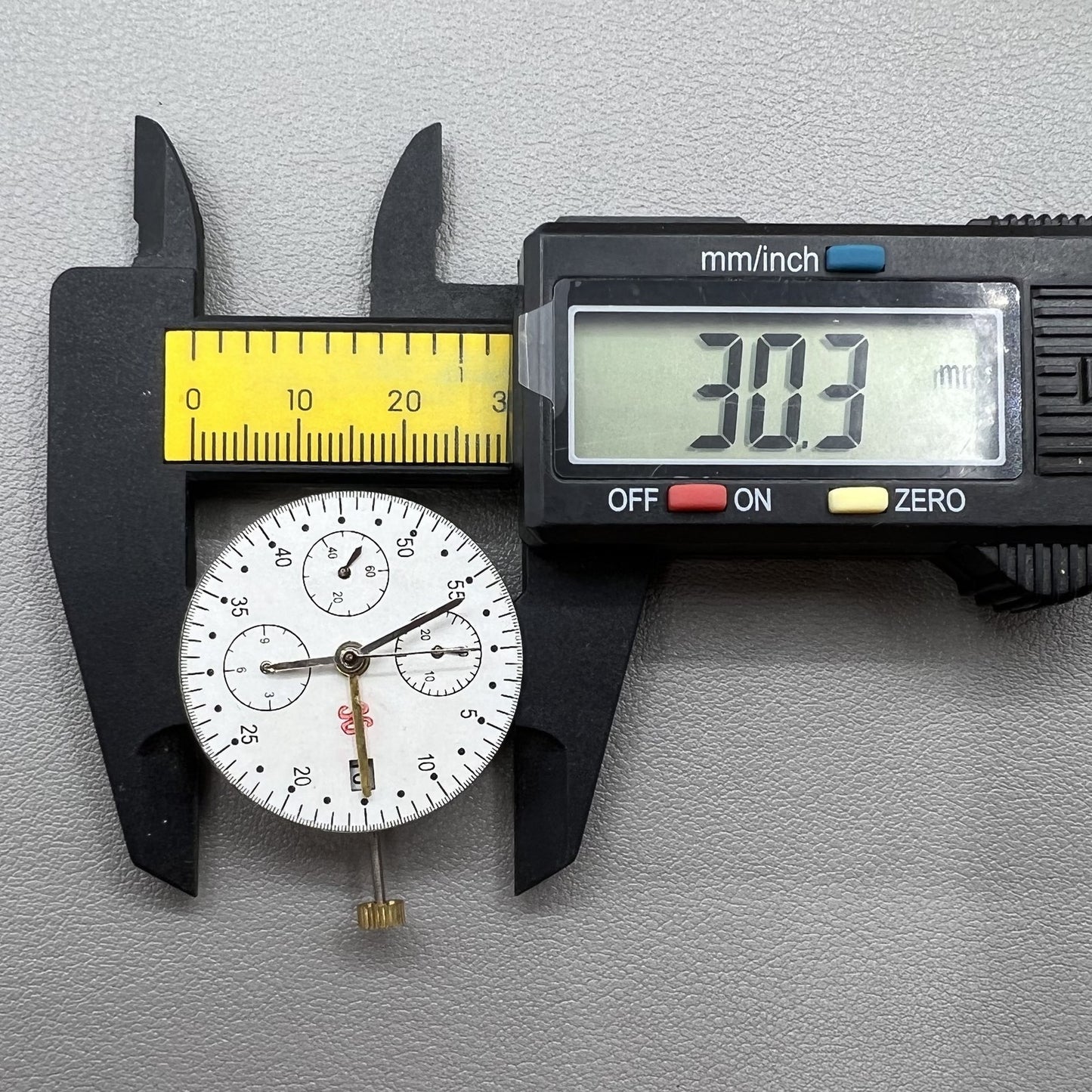 Dandong 7750 mechanical watch movement showing calendar and small subdials at 6, 9, 12 o'clock positions.