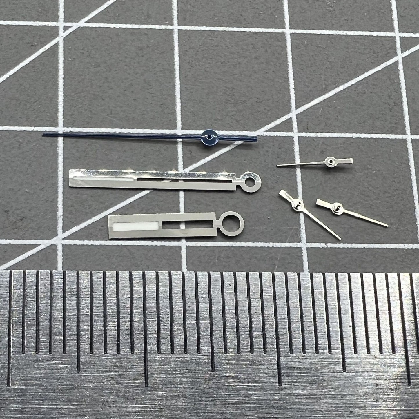 Luminous silver watch hands for Ronda 5021D quartz movement, enhancing readability in low light.